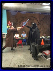 Jedi Master Chris battles Darth Vader at a Star Warriors birthday party at the Santa Maria Valley Discovery Museum.